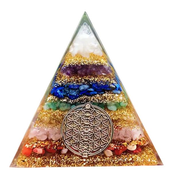 Vista frontal da Orgonite Pirâmide 7 Chakras com camadas de cristais coloridos e símbolo da flor da vida em metal dourado.