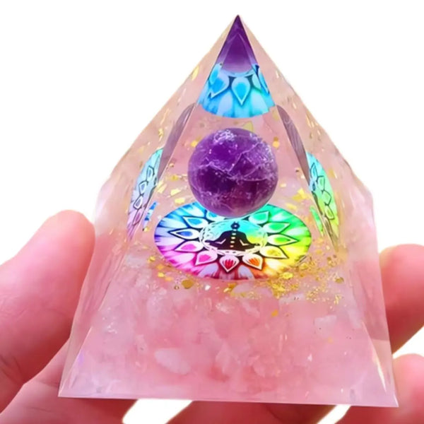 Close-up de uma pirâmide de Orgonite com Quartzo Rosa e 7 Chakras, mostrando detalhes da esfera central e das cores vibrantes dos Chakras.